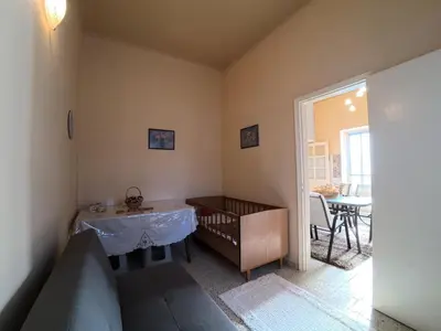 a bedroom with a crib and a table in a room at Traditional Villa Stella in Archangelos