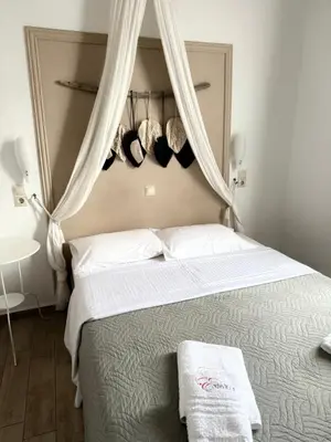 a bedroom with a bed with curtains above it at Evdokia Old Town Hotel in Rhodes Town