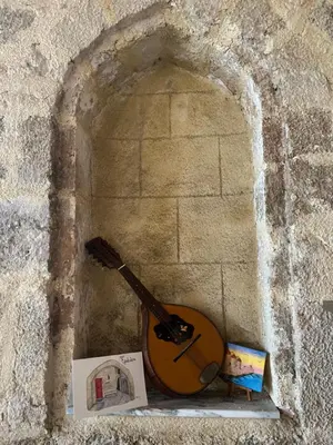 a guitar sitting on a stone wall with a book at Evdokia Old Town Hotel in Rhodes Town