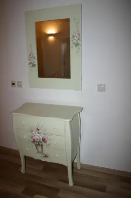 a white dresser with a mirror and flowers on it at Evdokia Old Town Hotel in Rhodes Town