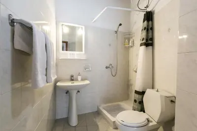 a white bathroom with a toilet and a sink at Evdokia Old Town Hotel in Rhodes Town