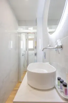 a white bathroom with a sink and a shower at Marizaf house in Émbonas