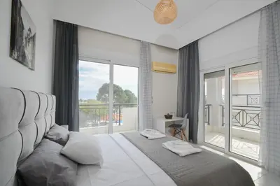 a bedroom with a large bed and a large window at Piccolo Paradiso Villas in Gennadi