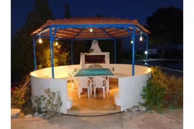 a table and chairs under a gazebo at night at Piccolo Paradiso Villas in Gennadi