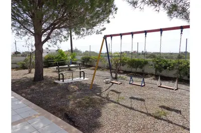 an empty playground with a bench and a swing at Piccolo Paradiso Villas in Gennadi