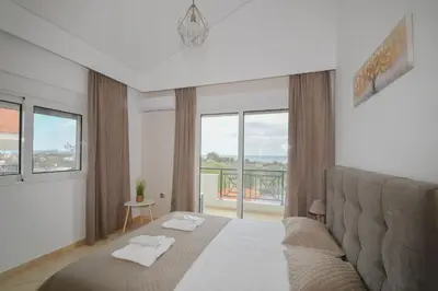 a bedroom with a bed and a large window at Piccolo Paradiso Villas in Gennadi