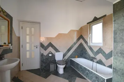 a bathroom with a tub and a toilet and a sink at Piccolo Paradiso Villas in Gennadi