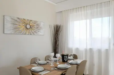 a dining room table with chairs and a table and a window at Piccolo Paradiso Villas in Gennadi