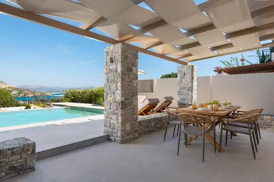 a patio with a table and chairs and a swimming pool at Villa Celestia in vlicha