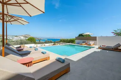 a swimming pool with chairs and an umbrella at Villa Celestia in vlicha