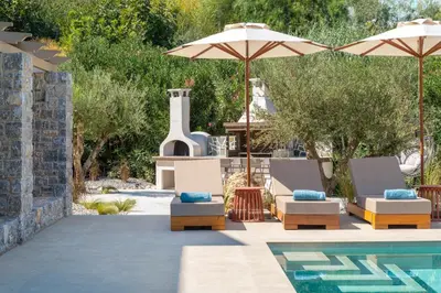 a pool with two lounge chairs and umbrellas at Villa Celestia in vlicha