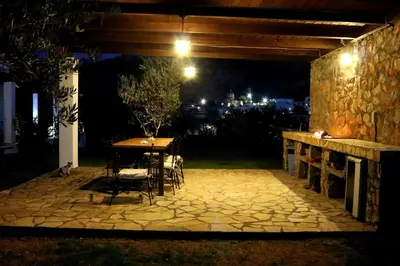a table and chairs on a patio at night at Villa Cleoboulos in Líndos