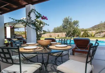 a patio with a table and chairs and a pool at Villa Cleoboulos in Líndos