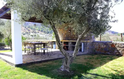 a patio with a table and a tree in a yard at Villa Cleoboulos in Líndos