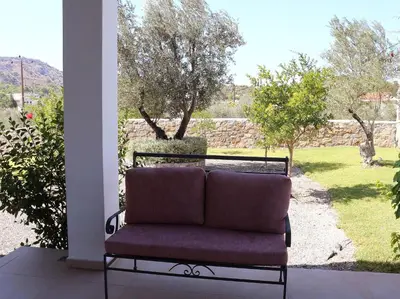 a couch sitting on a porch looking out at a yard at Villa Cleoboulos in Líndos