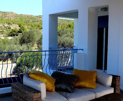 a living room with a couch and a balcony at Villa Cleoboulos in Líndos