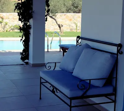 a blue couch sitting on a patio with a pool at Villa Cleoboulos in Líndos