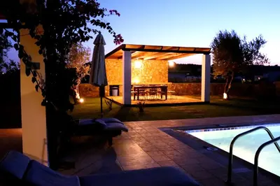a patio with a table and an umbrella next to a pool at Villa Cleoboulos in Líndos