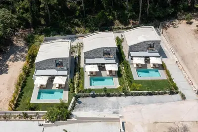 an overhead view of a mansion with two swimming pools at Rokas Luxury Villas in Asgourou