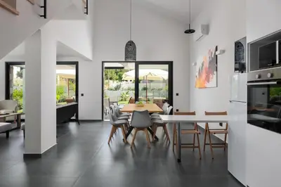 a kitchen and dining room with a table and chairs at Rokas Luxury Villas in Asgourou
