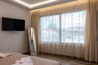 a bedroom with a large window and a television at Villa Ceroni in vlicha