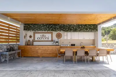 a kitchen and dining room with a wooden table and chairs at Villa Ceroni in vlicha