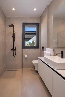 a bathroom with a sink and a toilet and a window at Amani Villas Lindos in Líndos