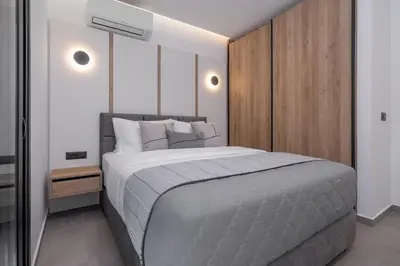 a bedroom with a large bed and a wooden wall at Amani Villas Lindos in Líndos