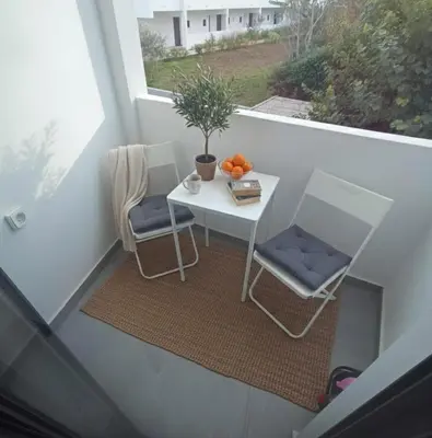 a small table and two chairs on a balcony at Nirea Tree View Studio in Faliraki