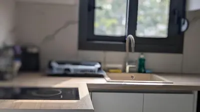 a kitchen counter with a sink and a window at Nirea Tree View Studio in Faliraki