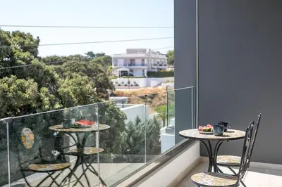 a balcony with two tables and chairs on a balcony at Rodos Nest with terrace and seaview in Asgourou