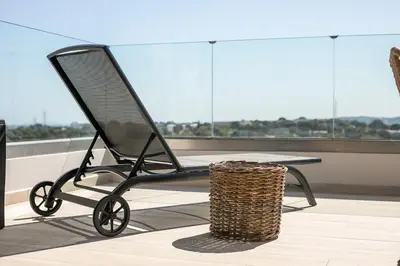 a black folding chair with a table and a basket at Rodos Nest with terrace and seaview in Asgourou
