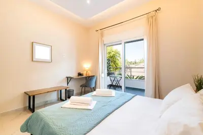 a bedroom with a bed and a desk and a window at Acropolis Gem in Rhodes Town