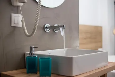 a bathroom sink with water coming out of it at Moscha Hotel in Faliraki