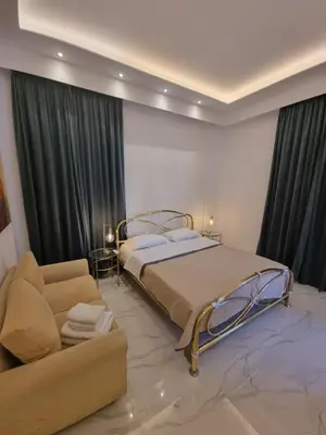 a bedroom with a bed and a couch at City center beach house in Rhodes Town