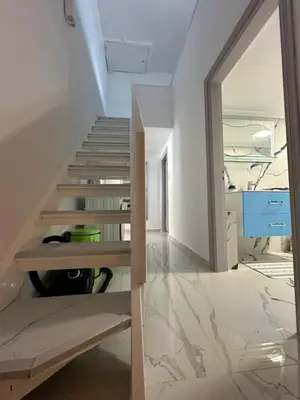 a staircase in a house with white walls and marble floors at City center beach house in Rhodes Town