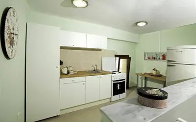 a kitchen with white cabinets and a white refrigerator at City center beach house in Rhodes Town