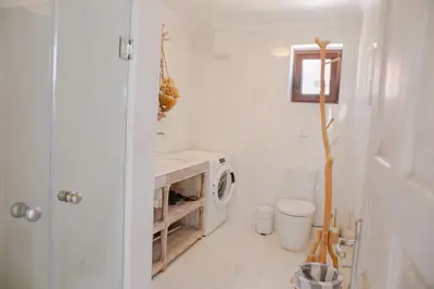 a white bathroom with a washing machine in it at Villa Aristoteles in Halki