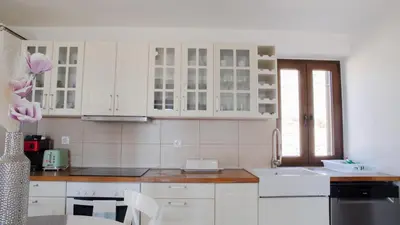 a kitchen with white cabinets and a sink at Villa Aristoteles in Halki