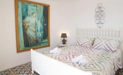 a bedroom with a bed with a painting on the wall at Villa Blu Majestic beach villa in Halki