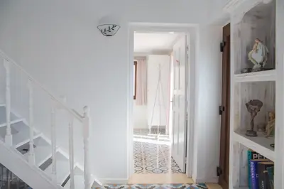 a hallway with white walls and a white stair case at Villa Blu Majestic beach villa in Halki