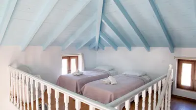 two beds in a room with blue ceilings at Villa Blu Majestic beach villa in Halki