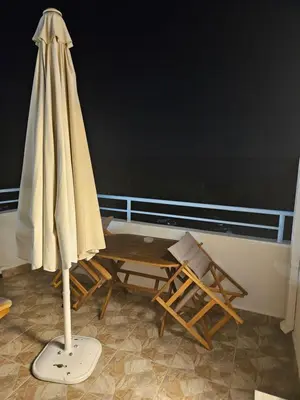 a umbrella and a chair and a table and a desk at St Paul's Studios Chrysanthi in Líndos
