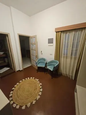 a living room with two chairs and a rug at St Paul's Studios Chrysanthi in Líndos