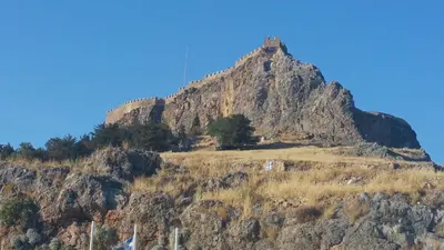a mountain with a tower on top of it at St Paul's Studios Chrysanthi in Líndos