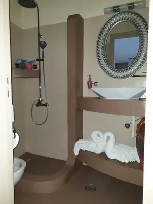 a bathroom with a sink and a toilet and a mirror at St Paul's Studios Chrysanthi in Líndos