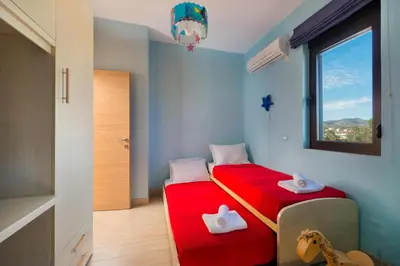 a bedroom with two beds and a window at Great Sand Villa in Gennadi