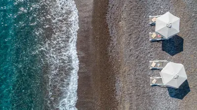 an overhead view of a beach with umbrellas and the ocean at Great Sand Villa in Gennadi