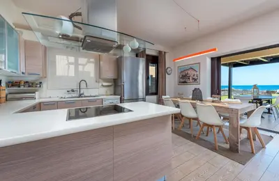 a kitchen with a table and a dining room at Great Sand Villa in Gennadi