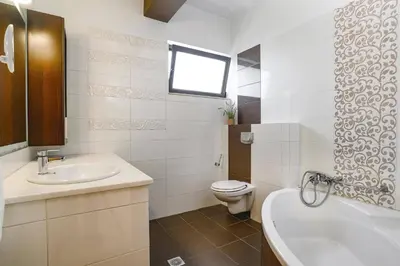 a bathroom with a sink and a toilet and a tub at Villa Kallisti Ialyssos by Villa Plus in Triánta